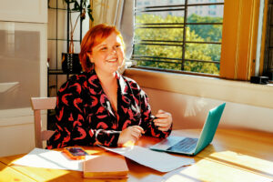 excited young woman working on laptop at home