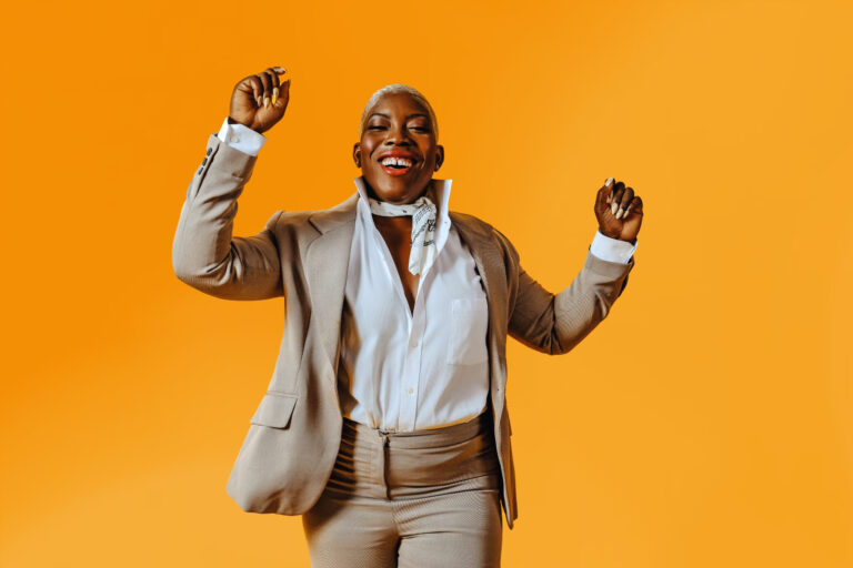 Woman wearing suit dancing celebrating success